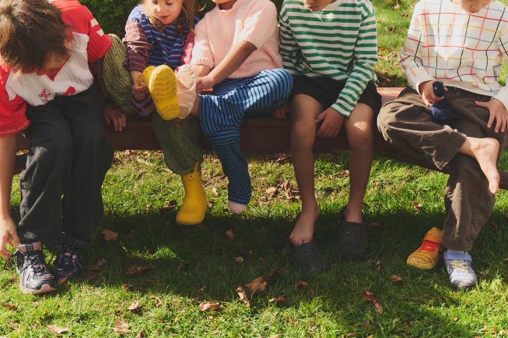Kids sitting on a bench putting on sports shoes before practice
